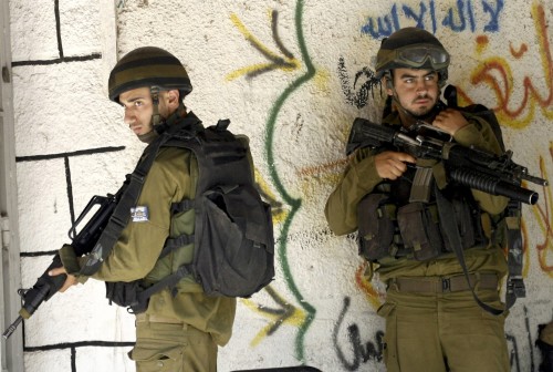 جنديان اسرائيليان خلال عملية عسكرية في الضفة الغربية أمس (عبد عمر قسيني - رويتز)