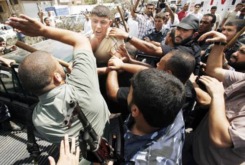 عناصر من «حماس» تعتدي على فتحاوي في غزّة أمس (صهيب سالم - رويترز)