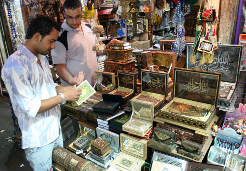 سوري يتصفّح قرآناً في أحد المتاجر وسط دمشق أمس (باسم تلاوي - أ ب)