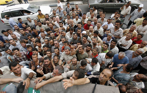 فلسطينيون يحتشدون أمام مصرف لتلقّي مساعدة من حكومة فياض في غزة أمس (محمد سالم ــ رويترز)