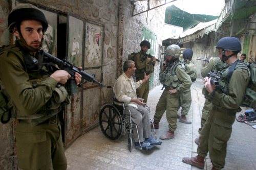 جنود إسرائيليون يستجوبون معتقلاً فلسطينياً في الخليل أمس (عبد الحفيظ هاشلمون ــ إي بي أي)