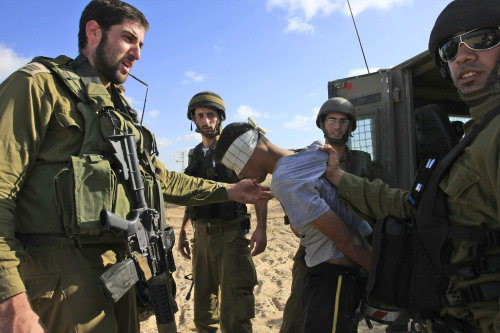 جنود إسرائيليون يقتادون فتى فلسطينيّاً في غزّة أمس (تسافرير أبايوف ـ أ ب)