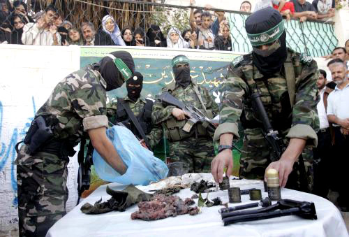 مقاومون من «حماس» يعرضون أشلاء وعتاد جندي إسرائيلي قتل في غزة أمس (إبراهيم أبو مصطفى ــ رويترز)