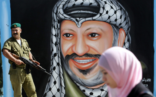 عنصر أمن فلسطيني قرب جداريّة للرئيس الراحل ياسر عرفات في جنين أمس (سيف دحلح ـ أ ف ب)