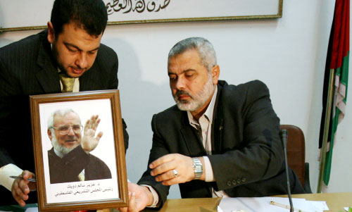 هنيّة يضع صورة رئيس المجلس التشريعي المعتقل عزيز الدويك خلال جلسة «التشريعي» في غزّة أمس (سيّد خطيب ــ أ ف ب)