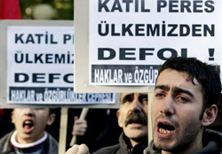 أتراك يحملون شعارات «بيريز قاتل» في أنقرة أمس (أوميت بيكتاش ـ رويترز)