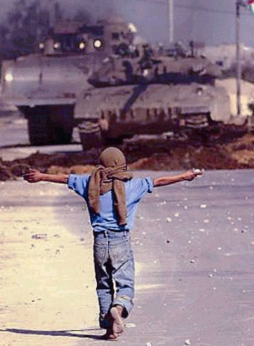 طفل يحمل حجراً في مواجهة دبابة إسرائيلية خلال الانتفاضة الأولى (أرشيف)