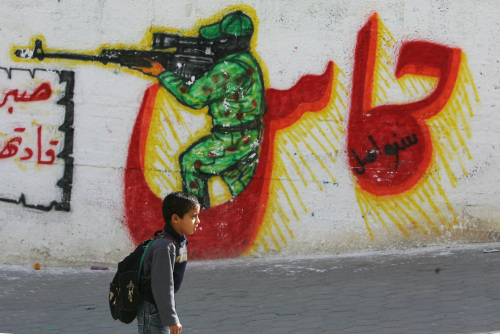 طفل فلسطيني يمرّ قرب جداريّة لـ«حماس» في غزّة أمس (محمّد عبد ـ أ ف ب)