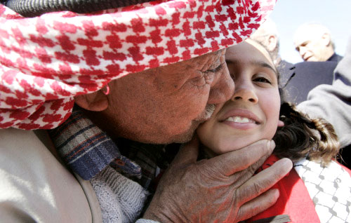 عجوز فلسطيني يقبّل قريبته التي عادت أمس إلى بيت لحم من قطاع غزّة (موسى الشاهر ــ أ ف ب)