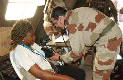 طبيب من السلك العسكري الفرنسي يفحص مواطنة تشاديّة تمّ إجلاؤها من نجامينا أمس (أ ب)