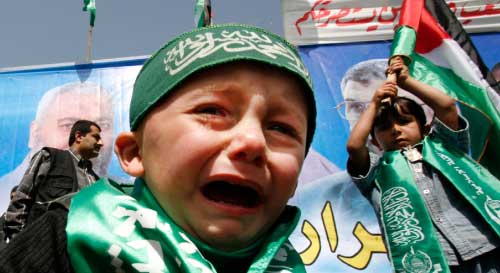 طفل فلسطيني يضع عصبة {حماس} على رأسه خلال مشاركته في تظاهرة حمساوية في غزة أمس (سهيب سالم ـ رويترز)