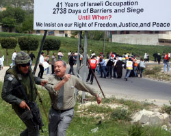 جندي اسرائيلي يعتقل متظاهراً فلسطينياً عند معبر الحوراء في الضفة الغربية أمس (جعفر اشتي - أ ف ب)
