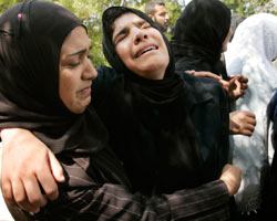 شقيقات أحد الشهداء يبكينه خلال تشييعه في غزة أمس (إبراهيم أبو مصطفى ـ رويترز)