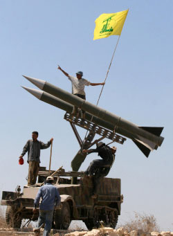 مناصرون لحزب الله يقفون على مجسّم لصاروخ في قرية برج قلاويه (أرشيف ـــ أ ب)