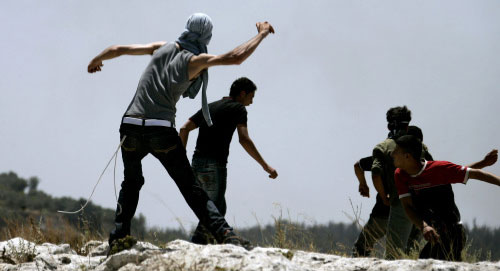 فلسطينيّون يرشقون جيش الاحتلال بالحجارة قرب جدار الفصل العنصري في نعلين أمس (عبّاس موماني ــ أ ف ب)