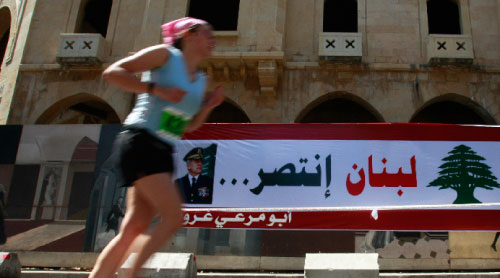 متسابق في «ماراثون بيروت» يمرّ أمام لافتة مرحّبة بانتخاب سليمان (جمال الصعيدي ـ رويترز)