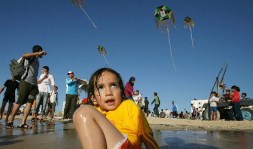 أطفال فلسطينيّون يلهون على شاطئ غزّة أول من أمس (محمود حمس ـــ أ ف ب)