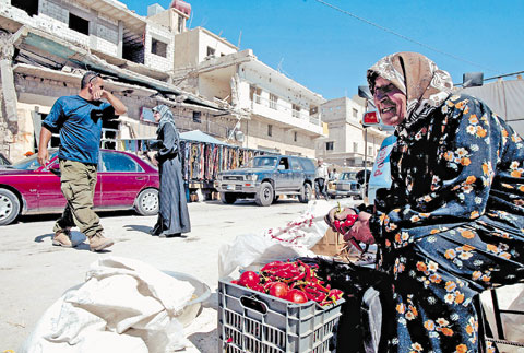 امرأة تبيع الخضار في سوق بنت جبيل (أ ف ب)