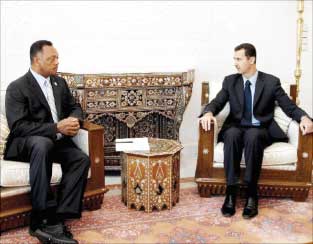 الرئيس السوري بشار الاسد مستقبلا القس الاميركي جسي جاكسون في دمشق أمس