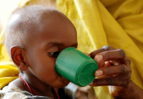 ام تطعم طفلها في مركز للعلاج في بلدة شمالي دارفور (رويترز)