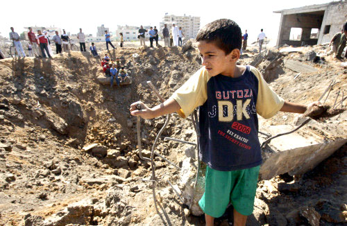 فلسطينيون قرب حفرة احدثها الطيران الاسرائيلية في مخيم رفح جنوب قطاع غزة أمس (أ ب)