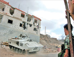 جندي لبناني يراقب آلية لليونيفيل في قرية يارون في جنوب لبنان أمس (أ ب)