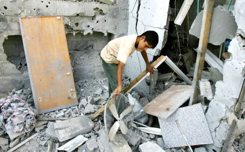 فتى فلسطيني يتفقد أنقاض منزله بعد قصف إسرائيلي لقطاع غزة أمس (أ ف ب)