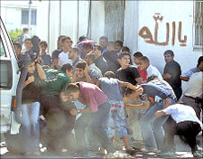 فلسطينيون يحتمون من الرصاص خلال تشييع أحد عناصر حرس الرئاسة في قطاع غزة أول من أمس (أ ف ب)