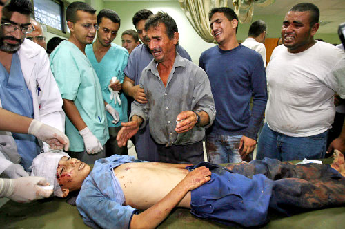 فلسطينيون ينتحبون على جثمان الطفل الشهيد صهيب قديح في غزة أمس (أ ف ب)