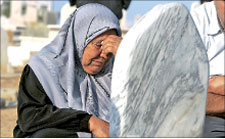 أم فلسطينية عند ضريح ابنها الشهيد في غزة أول من أمس (رويترز)