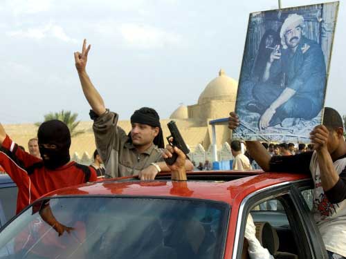 عراقيون يرفعون صورة صدام في تكريت احتجاجاً على حكم الاعدام (أ ب)