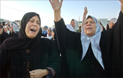 عراقيتان تنتحبان خلال مأتم في كركوك أمس (أ ب)
