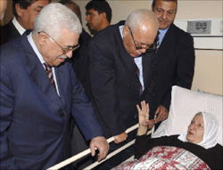 عباس خلال زيارته شقيقة الرئيس الفلسطيني الراحل ياسر عرفات في مستشفى الهلال في غزة أمس (رويترز)