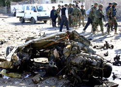 جنود عراقيون وأميركيون يتجمعون في موقع تفجير انتحاري في كركوك أمس (أي بي أي)