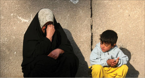عراقيّة تنتظرجثمان ابنها الذي قضى في تفجيرات الثلاثاء الماضي خارج مستشفى اليرموك في بغداد أمس (أ ب)