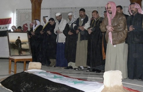 عراقيّون يصلّون على نعش صدّام في العوجة الأحد (رويترز)