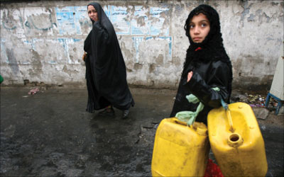 عراقية وابنتها متجهتان إلى محطة للوقود في بغداد أمس (أ ب)