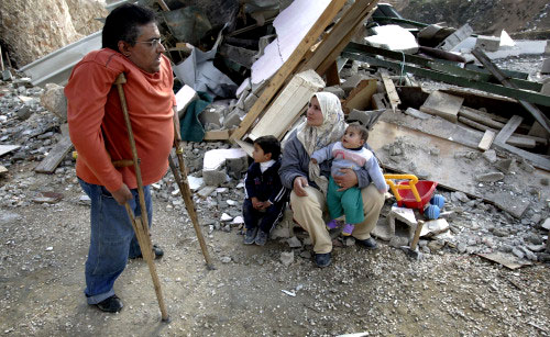 فلسطيني معوّق وعائلته يتفقّدون أنقاض منزلهم الذي دمّرته الجرّافات الإسرائيليّة في القدس المحتلّة أمس (أ ب)