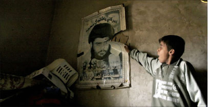فتى عراقي يتفقّد ملصقاً لمقتدى الصدر بعد غارة أميركيّة في منزله في مدينة الصدر أمس (أ ف ب)