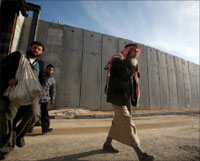 فلسطينيّون قرب الجدار الفاصل في بلدة الرام شرقي القدس الثلاثاء الماضي (إي بي أي)