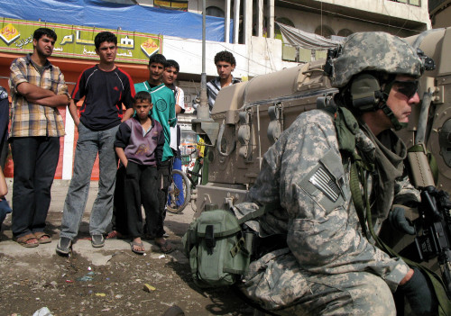 عراقيّون يراقبون جنديّاً أميركيّاً في مدينة الصدر في بغداد أمس (أ ب)