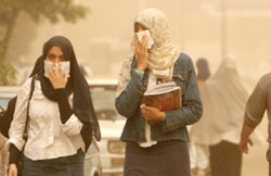 مصريّتان خلال عاصفة رمليّة في القاهرة أوّل من أمس (خالد دسوقي - أ ف ب)