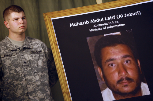 جندي اميركي يحمل صورة لـ «وزير الاعلام» في القاعدة عبد اللطيف الجبوري الذي قتلته القوات الاميركية أمس (احمد