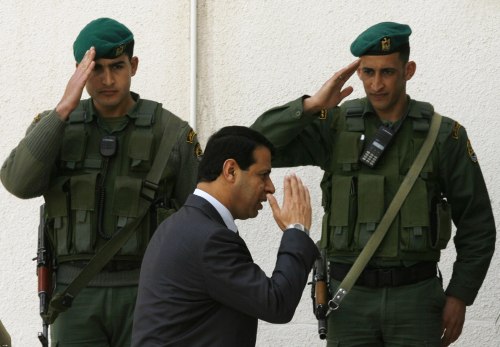 دحلان يتلقى التحية العسكرية من حارسين أمام مقر الرئاسة في رام الله في آذار الماضي (إليانا أبونت - رويترز)