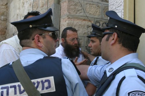 عناصر من الشرطة الإسرائيليّة يمنعون مستوطنين من الاعتداء على نواب عرب في الخليل أمس (عبد الحفيظ حشلمون - إي بي أي)