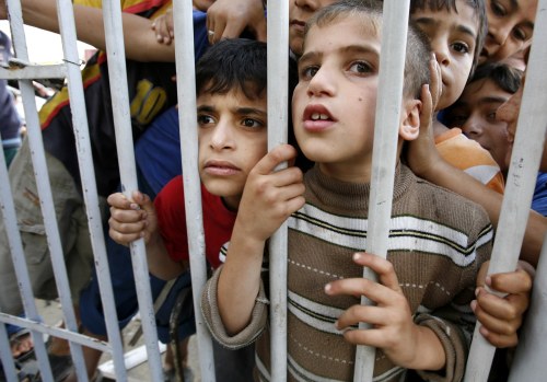 أطفال فلسطينيون ينظرون الى الدمار الذي أحدثته الغارات الاسرائيلية على غزة أمس (ابراهيم أبو مصطفى - رويترز)