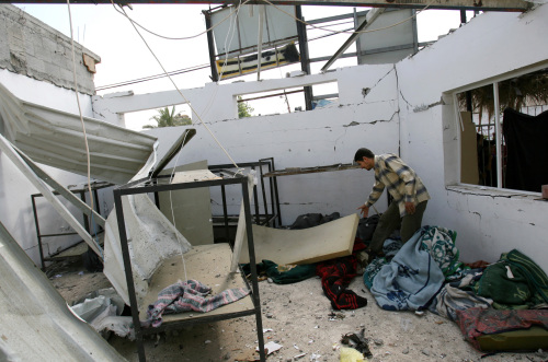 فلسطيني بين انقاض مركز للقوة التنفيذية استهدفته إسرائيل في غزة أمس (سعيد خطيب - أ ف ب)