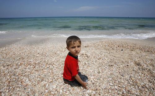 طفل فلسطيني على شاطئ خان يونس في غزّة أمس (ابراهيم أبو مصطفى - رويترز)