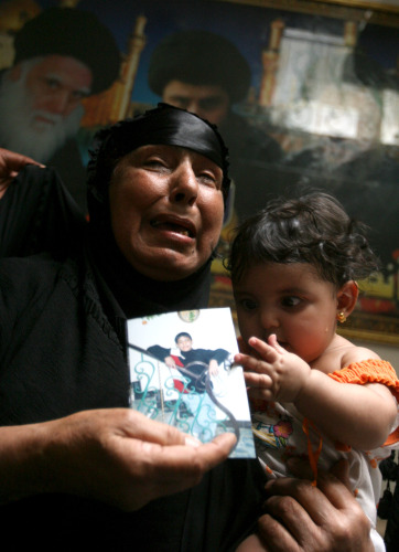 عراقية تحمل صورة لحفيدها (13 عاماً) المعتقل لدى الأميركيين في بغداد أمس (خالد محمد - أ ب)
