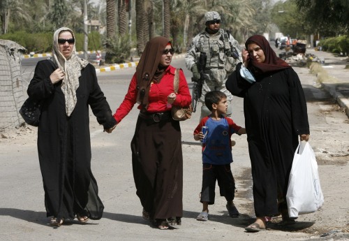 عراقيات أمام جندي أميركي في بغداد أمس (نيكولا سوليك - رويترز)